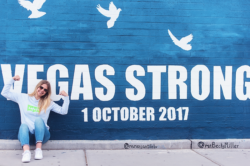 Portrait d'un photographe professionnel posant devant le mur "Vegas Strong"